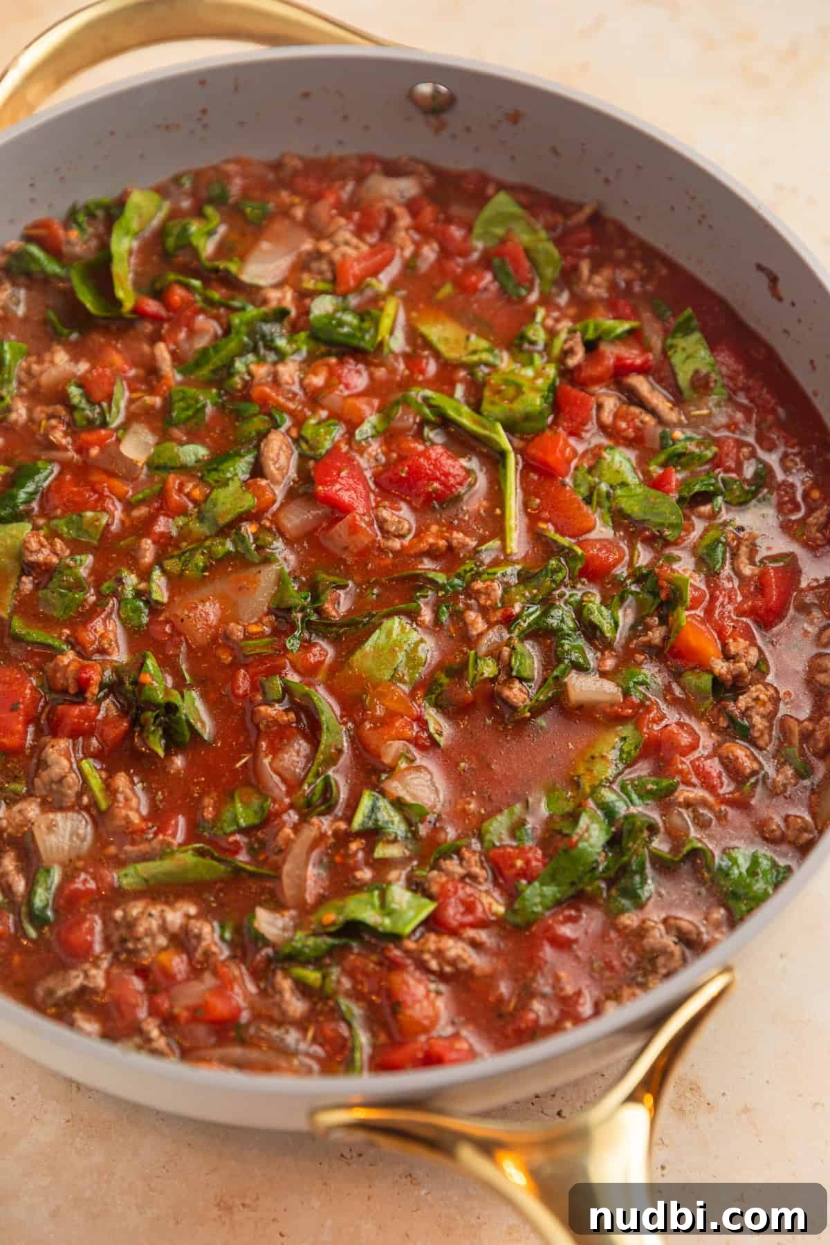 One-Skillet Ground Beef Pasta Skillet Meal 6 Beef, broth, tomatoes and other ingredients simmering in skillet.