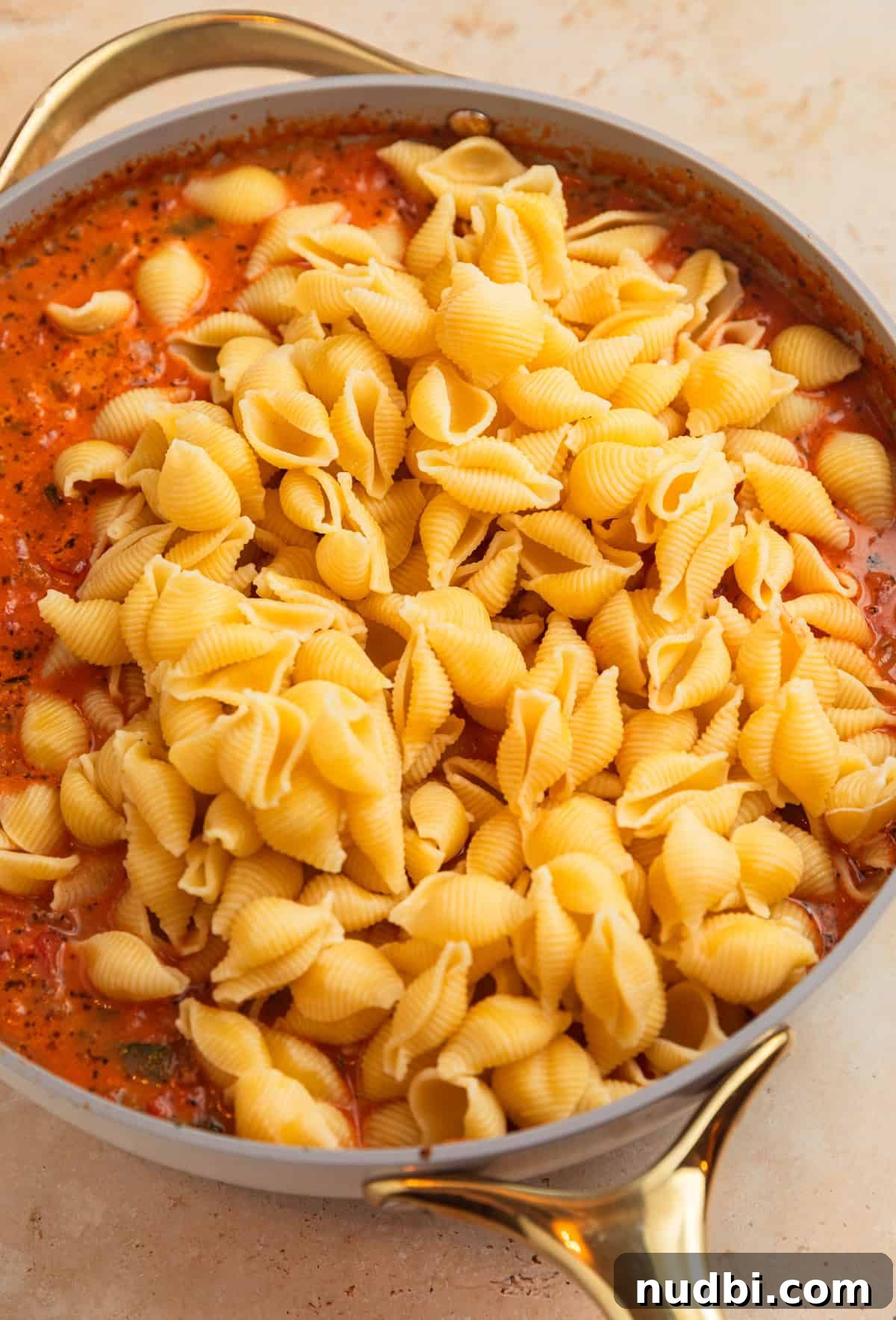 One-Skillet Ground Beef Pasta Skillet Meal 9 Pasta added to ground beef tomato mixture in pot.