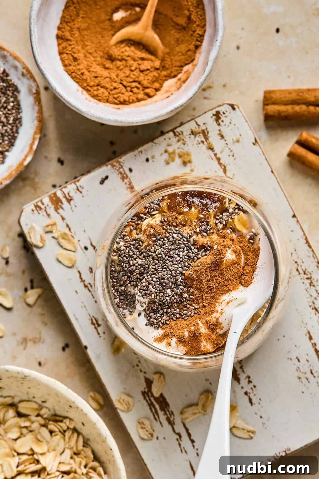 Cinnamon Roll Overnight Oats Recipe for Quick Morning Bliss 4 Jar with rolled oats, cinnamon, chia seeds and other ingredients before stirring.
