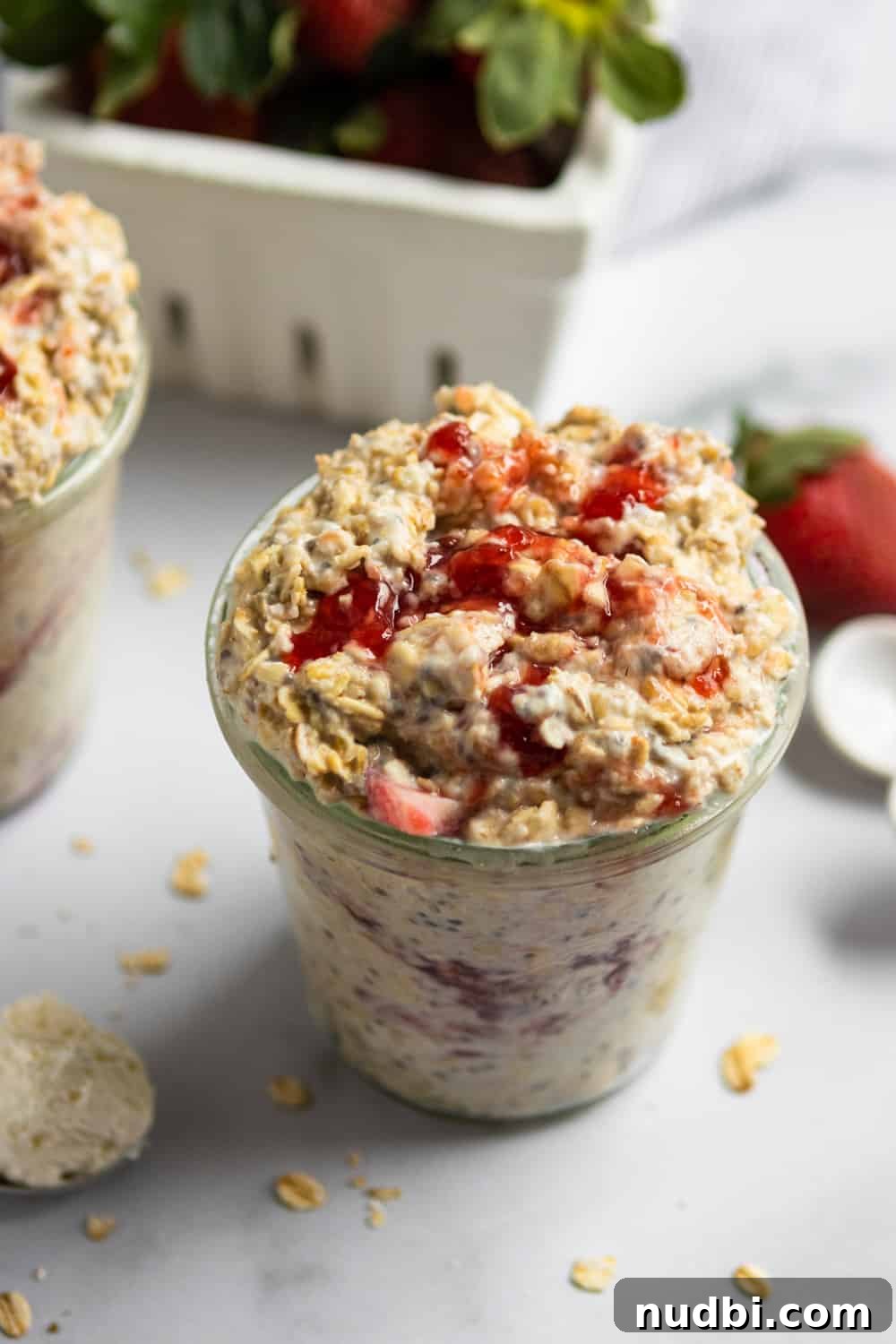 Strawberry Cheesecake Overnight Oats Recipe for Creamy Breakfast 4 Overnight oatmeal with strawberries and jam in glass jar.