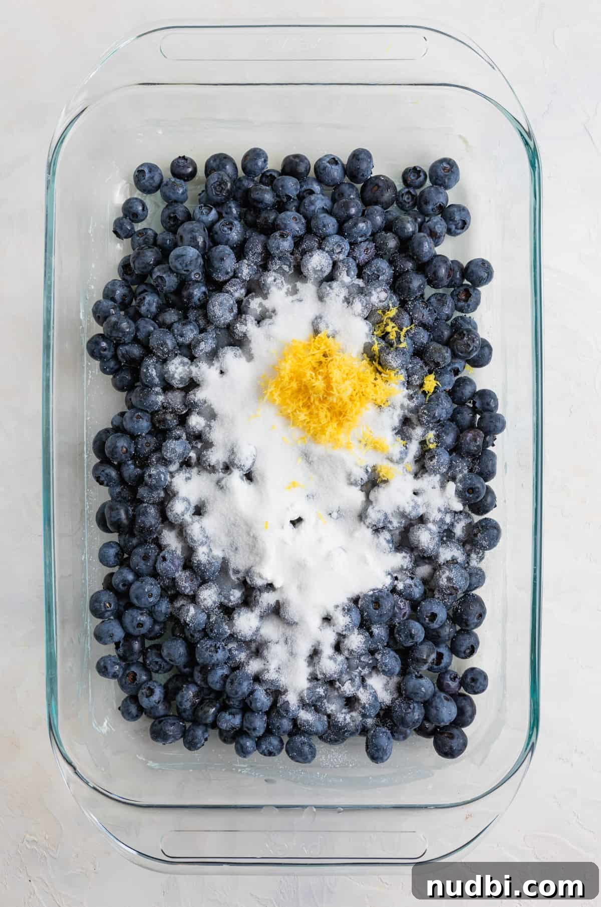 Lemon Blueberry Dump Cake Recipe for Quick Summer Desserts 4 Fresh blueberries, sugar, lemon zest in 9x13 inch glass pan.