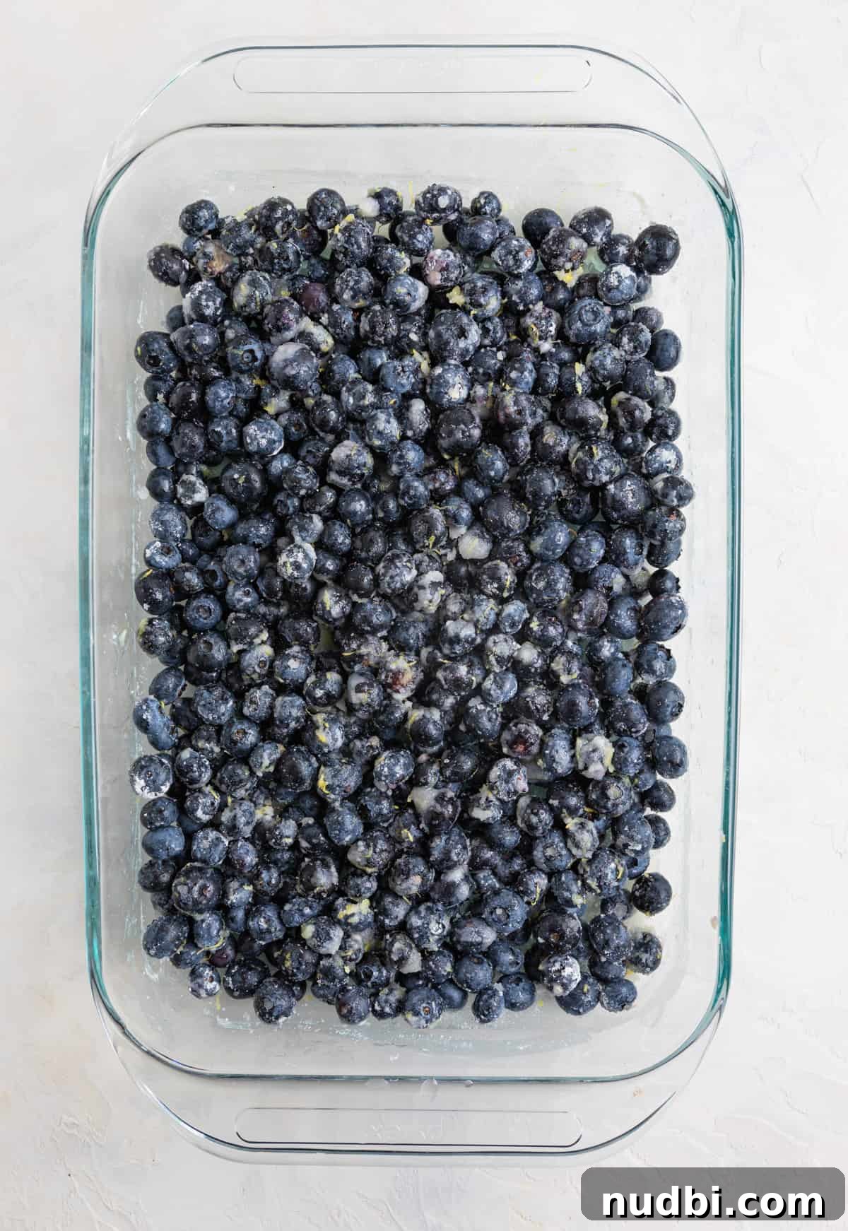Lemon Blueberry Dump Cake Recipe for Quick Summer Desserts 5 Prepared blueberries in glass baking pan ready for dump cake topping.