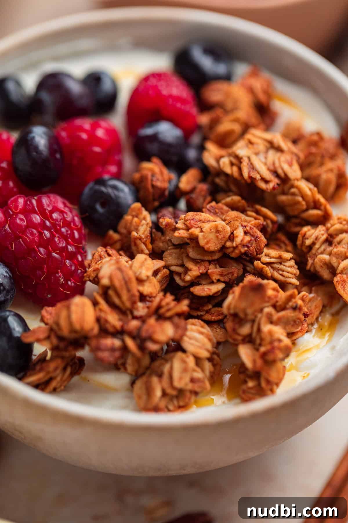 Banana Bread Granola Recipe — Crunchy Banana Oat Clusters 11 Banana granola on yogurt in bowl with berries.