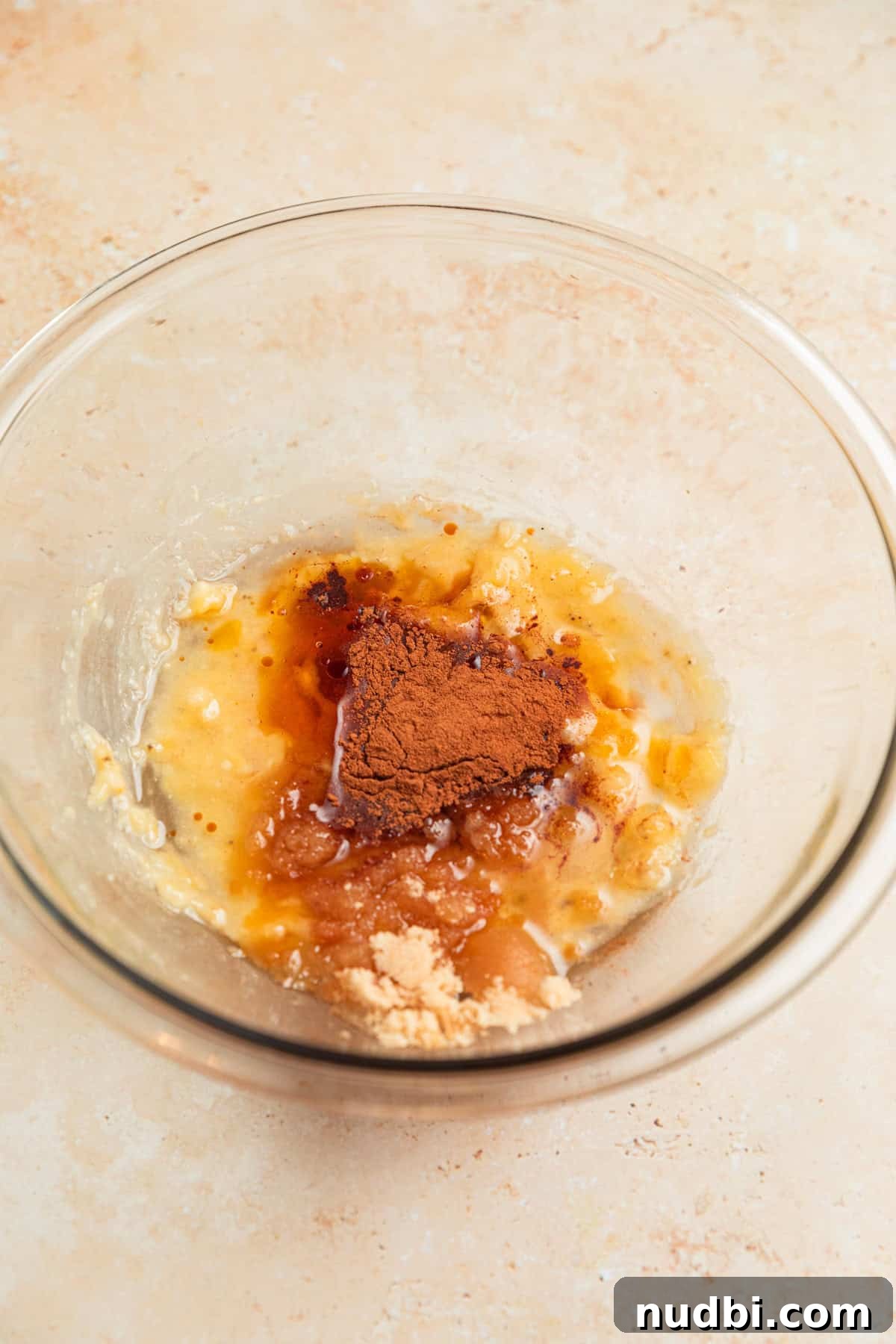 Banana Bread Granola Recipe — Crunchy Banana Oat Clusters 6 Coconut oil, maple syrup and other ingredients added to mashed banana in bowl.