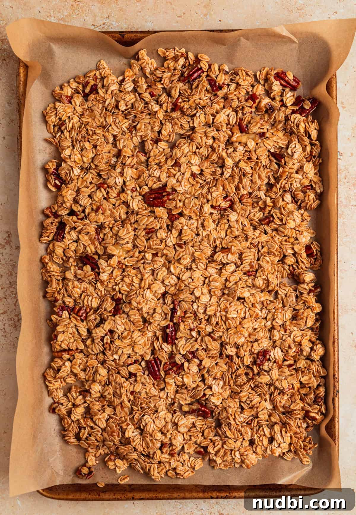 Banana Bread Granola Recipe — Crunchy Banana Oat Clusters 9 Baking sheet with parchment and granola mixture evenly placed before baking.