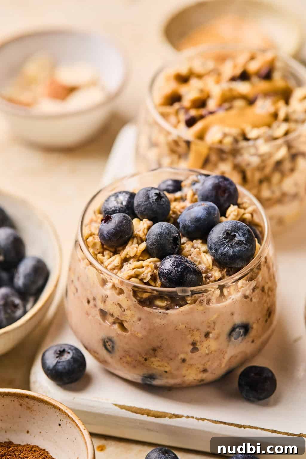 6 Overnight Oats Recipes for Quick, Nutritious Breakfasts 8 Blueberry muffin oatmeal prepared in glass jar topped with berries.