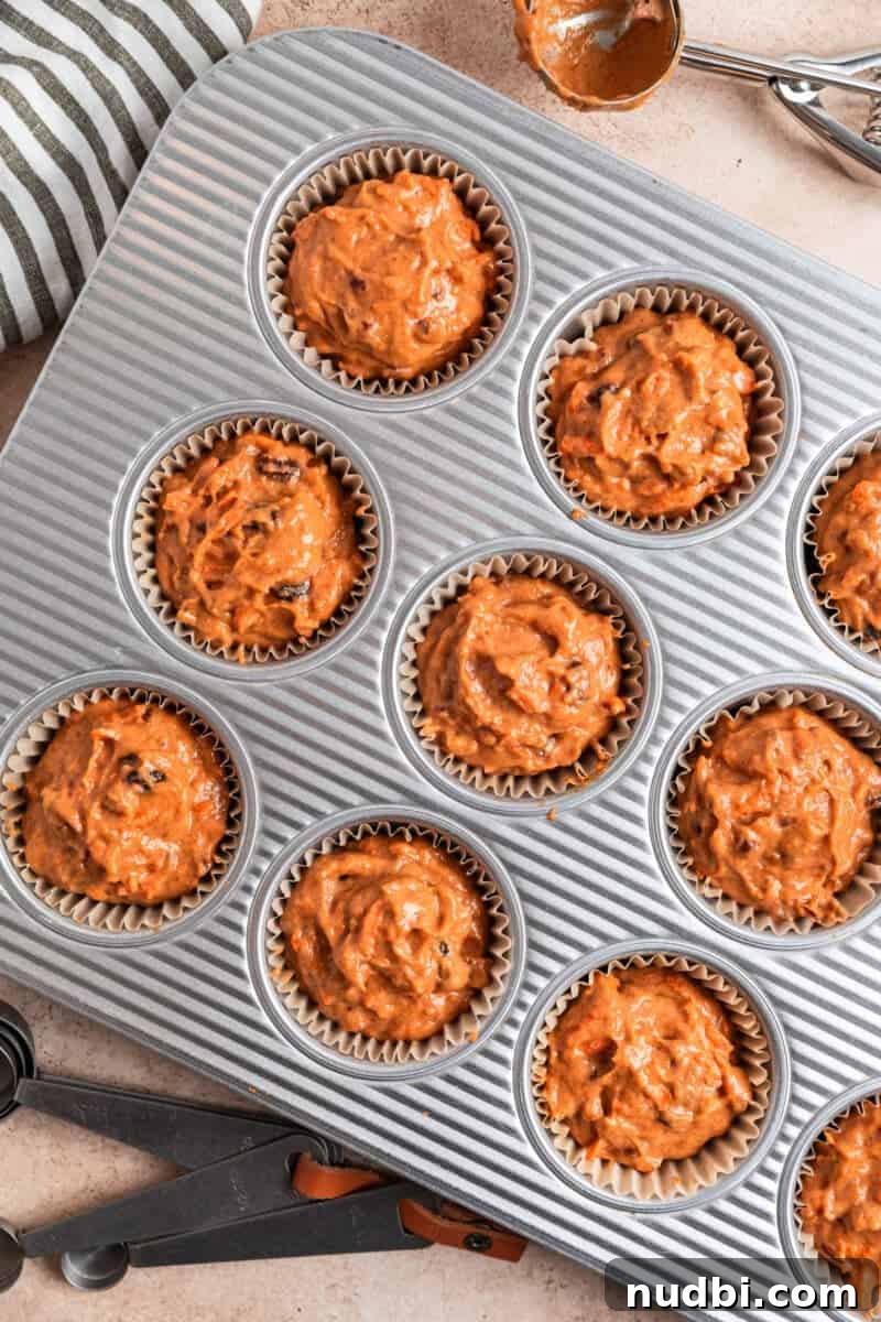 Moist Pumpkin and Carrot Muffins with Warm Spices 6 Muffin batter evenly scooped into parchment lined muffin tins.