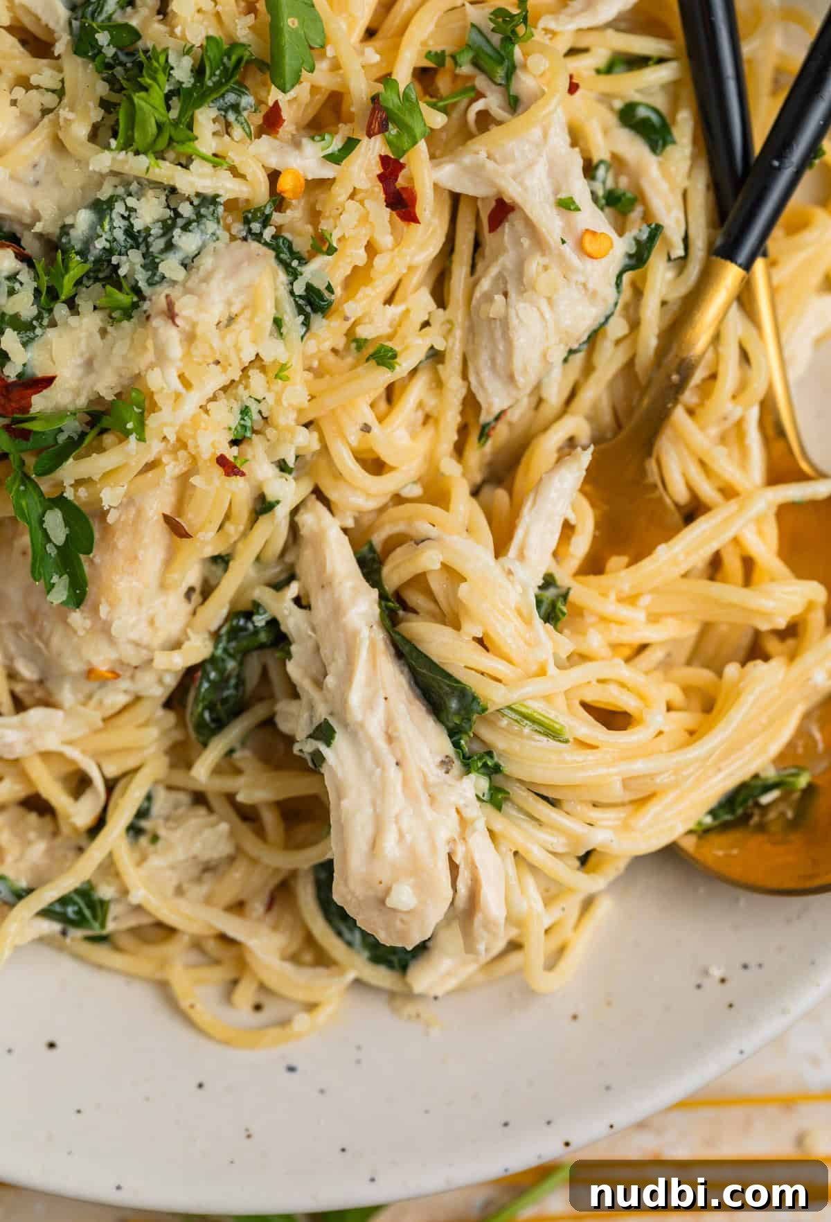 Creamy Parmesan Chicken in the Instant Pot: Tender 30-Minute Recipe 8 Forkful of pasts with creamy chicken and spinach on plate.