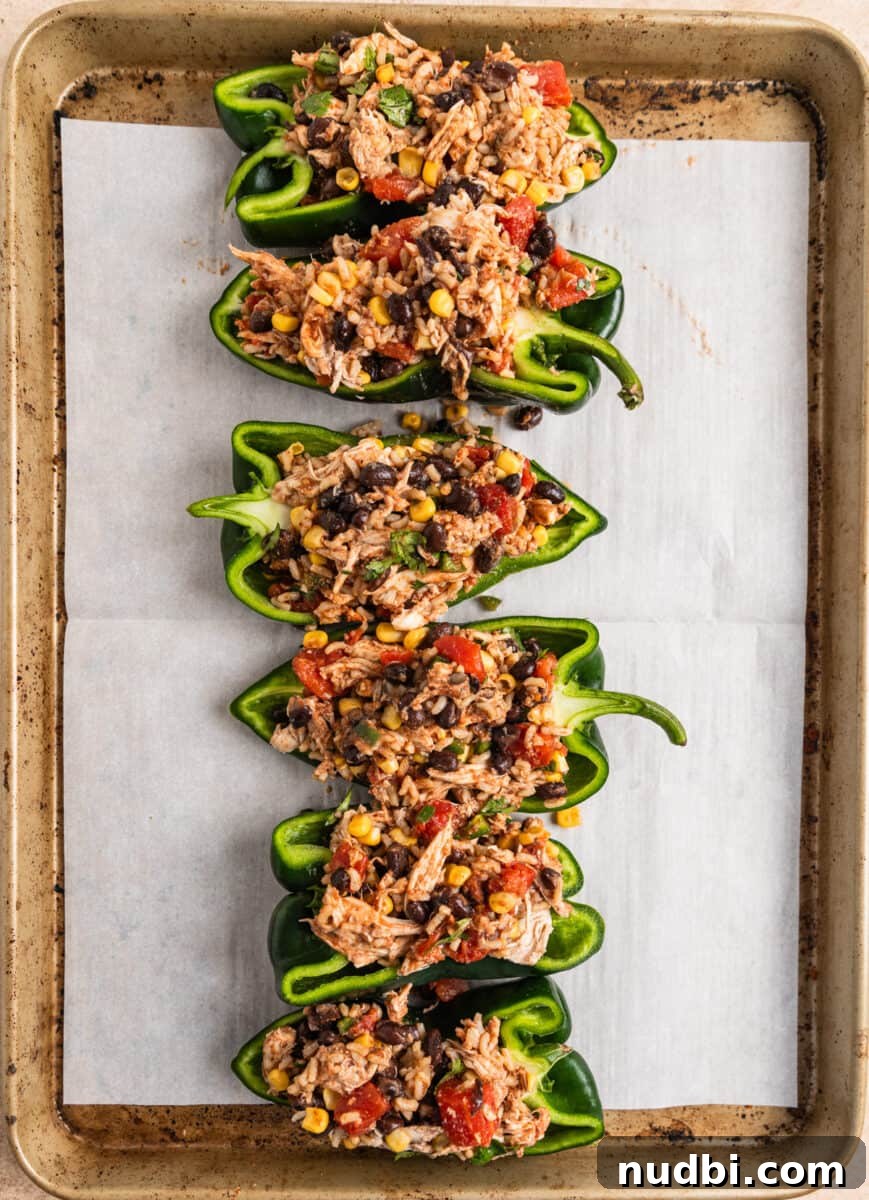 Chicken-Stuffed Poblano Peppers with Savory Cheese Filling 6 Poblano peppers halved and filled with chicken, rice and bean mixture on baking sheet.