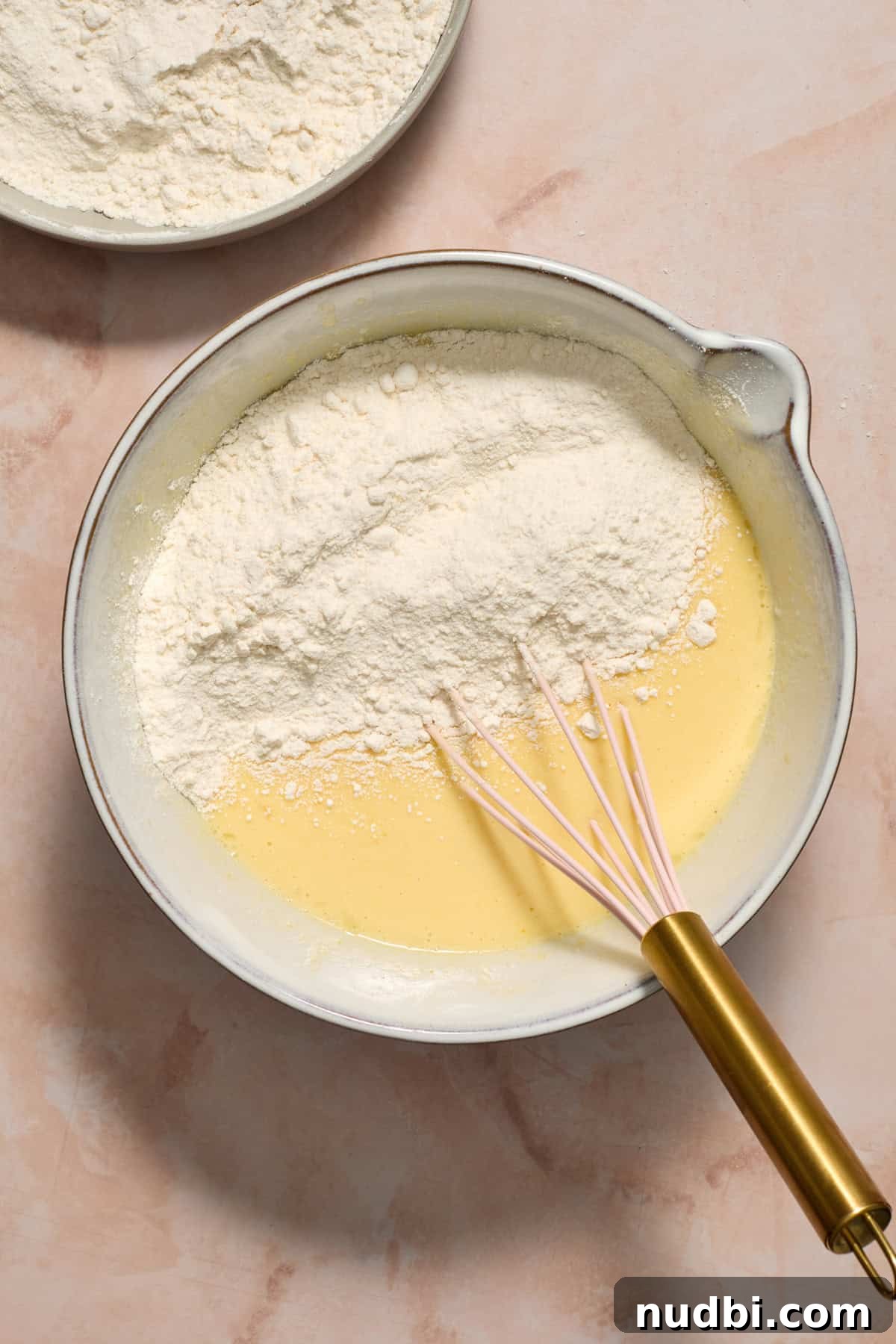 Perfect Cupcake Recipes Using Cake Mix for Fluffy Results 7 Cake mix added to wet ingredients in bowl with whisk.