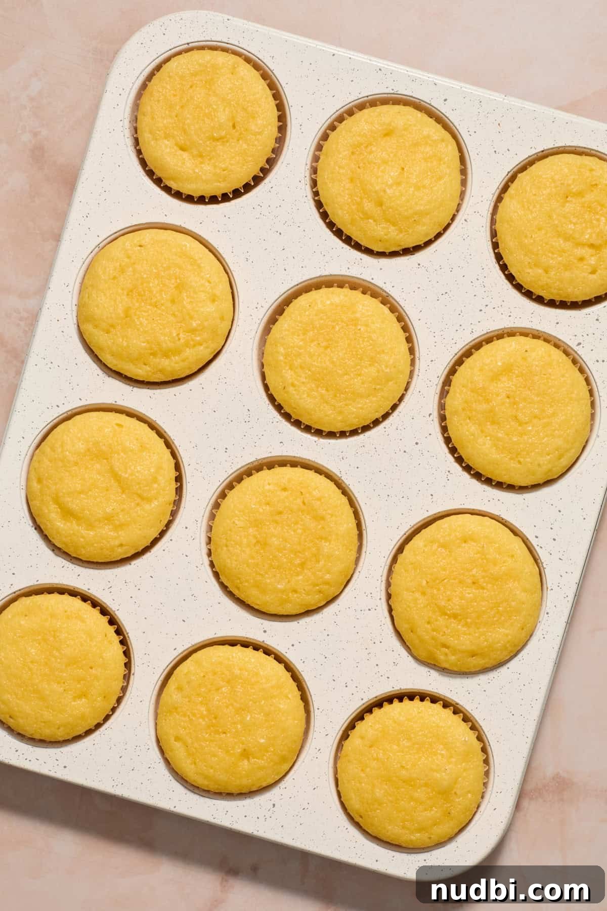 Perfect Cupcake Recipes Using Cake Mix for Fluffy Results 10 Baked vanilla cupcakes in muffin tin.