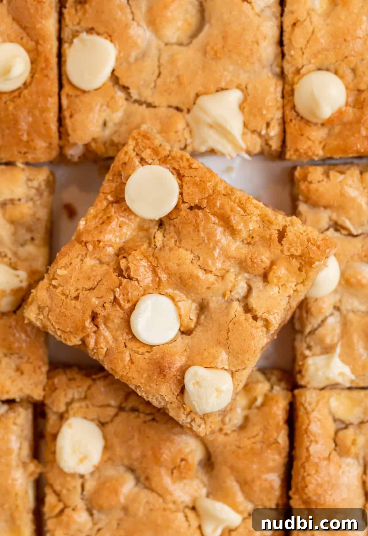 Chewy Gluten-Free Blondies Recipe That Melts in Your Mouth 2 Gluten free almond flour blondies with white chocolate chips lined up with top slice tilted slightly.