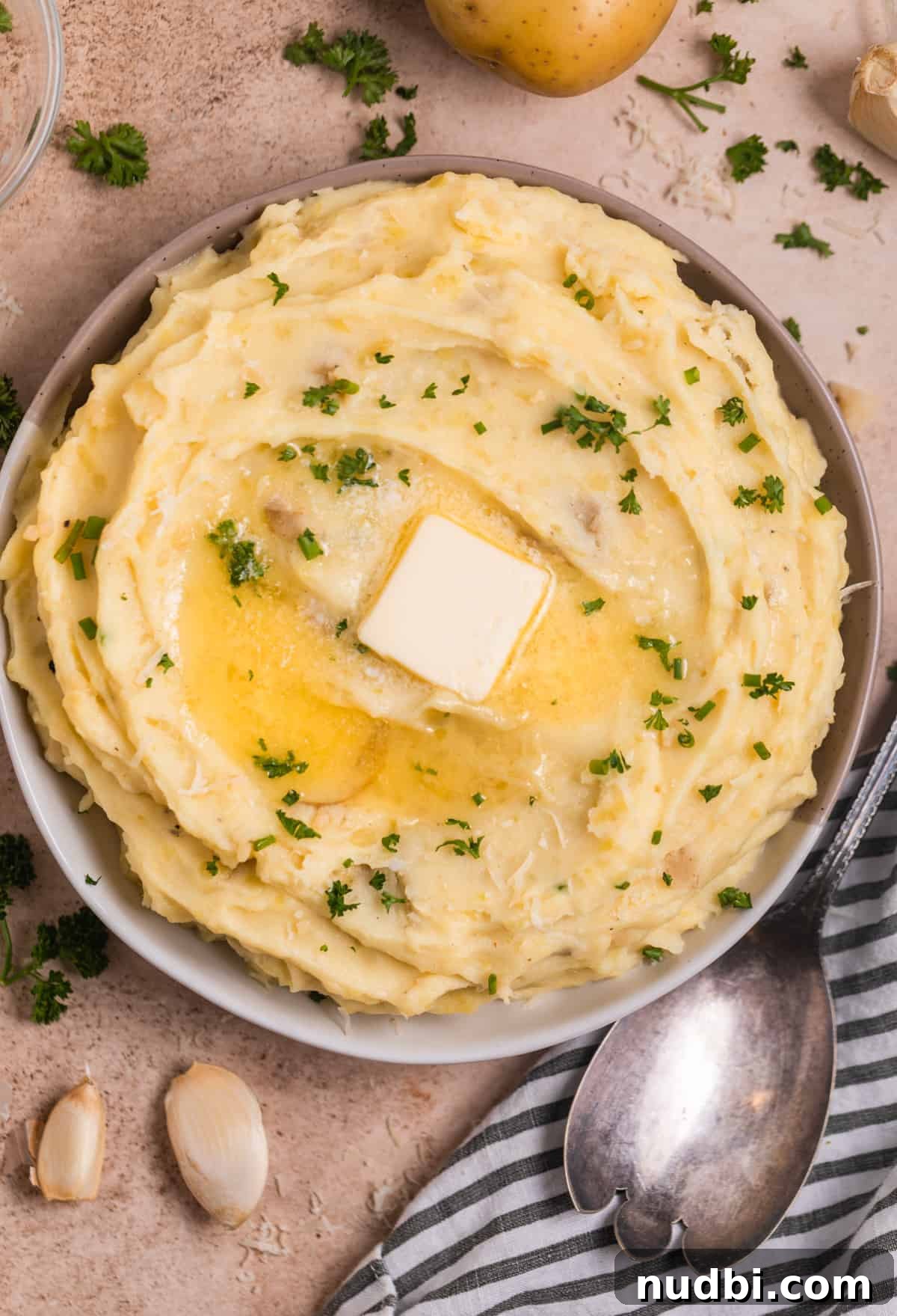 Garlic Parmesan Mashed Potatoes Made in the Instant Pot 2 Bowl of Instant pot mashed potatoes topped with butter, chopped parsley and chives on top.