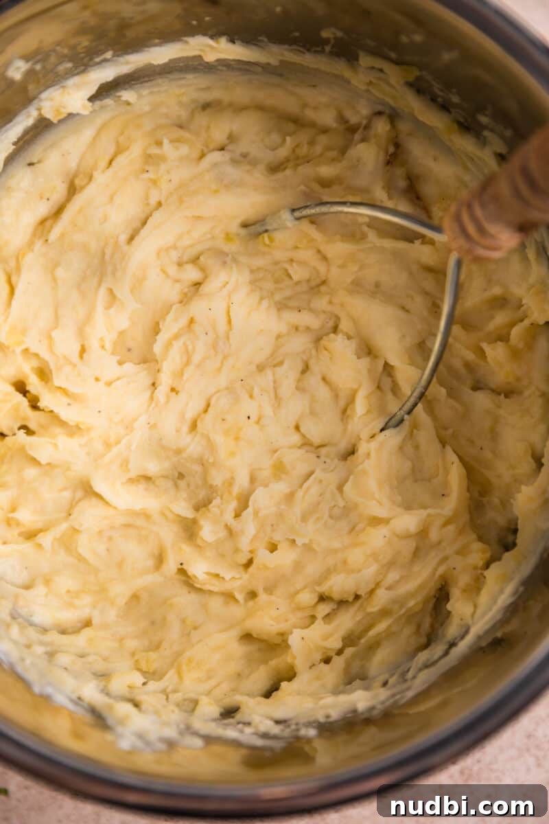 Garlic Parmesan Mashed Potatoes Made in the Instant Pot 6 Potato masher in Instant pot after mashing.