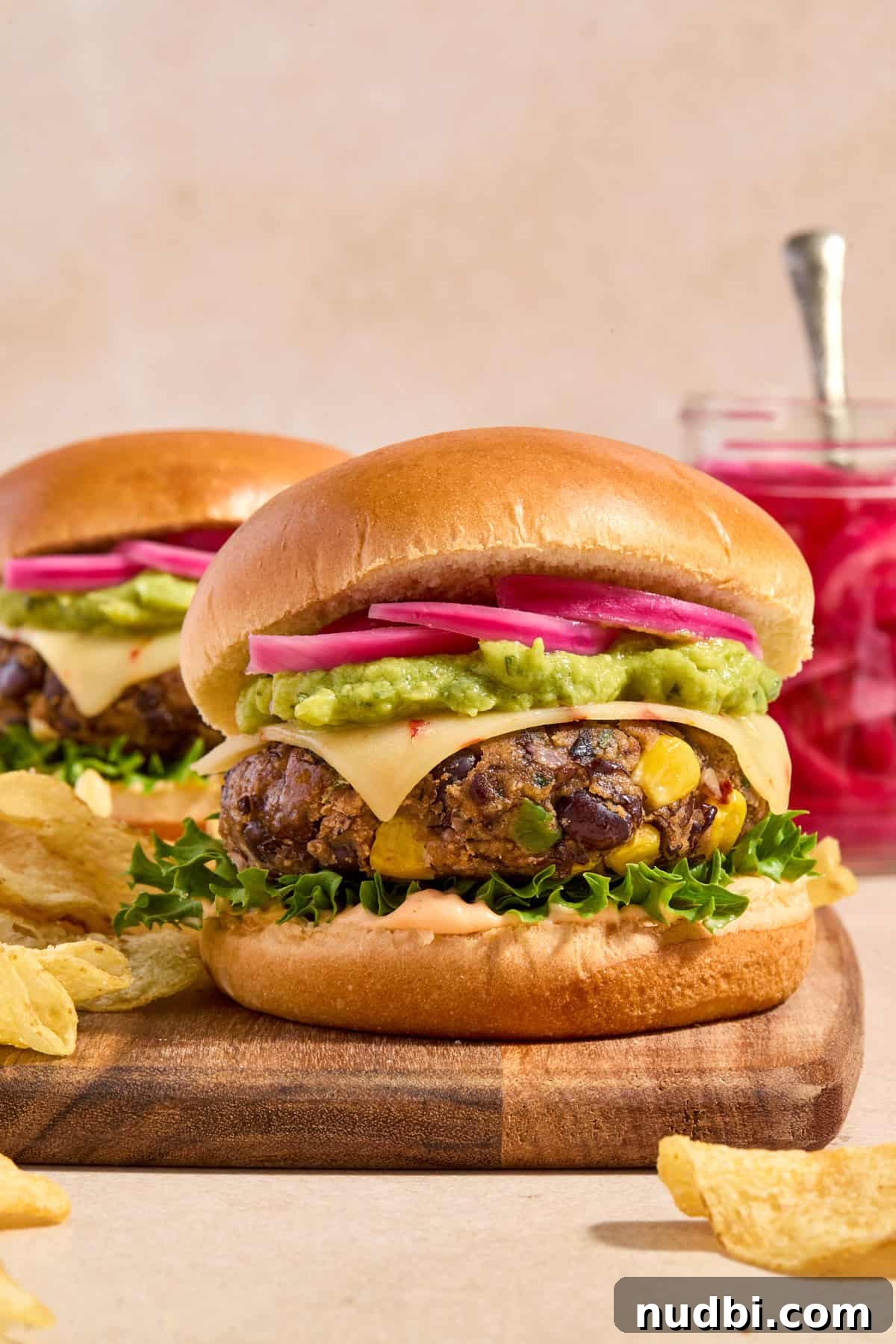 Spicy Cilantro Lime Black Bean Burgers 2 Spicy cilantro lime black bean burgers with chips and jar of pickles onions.