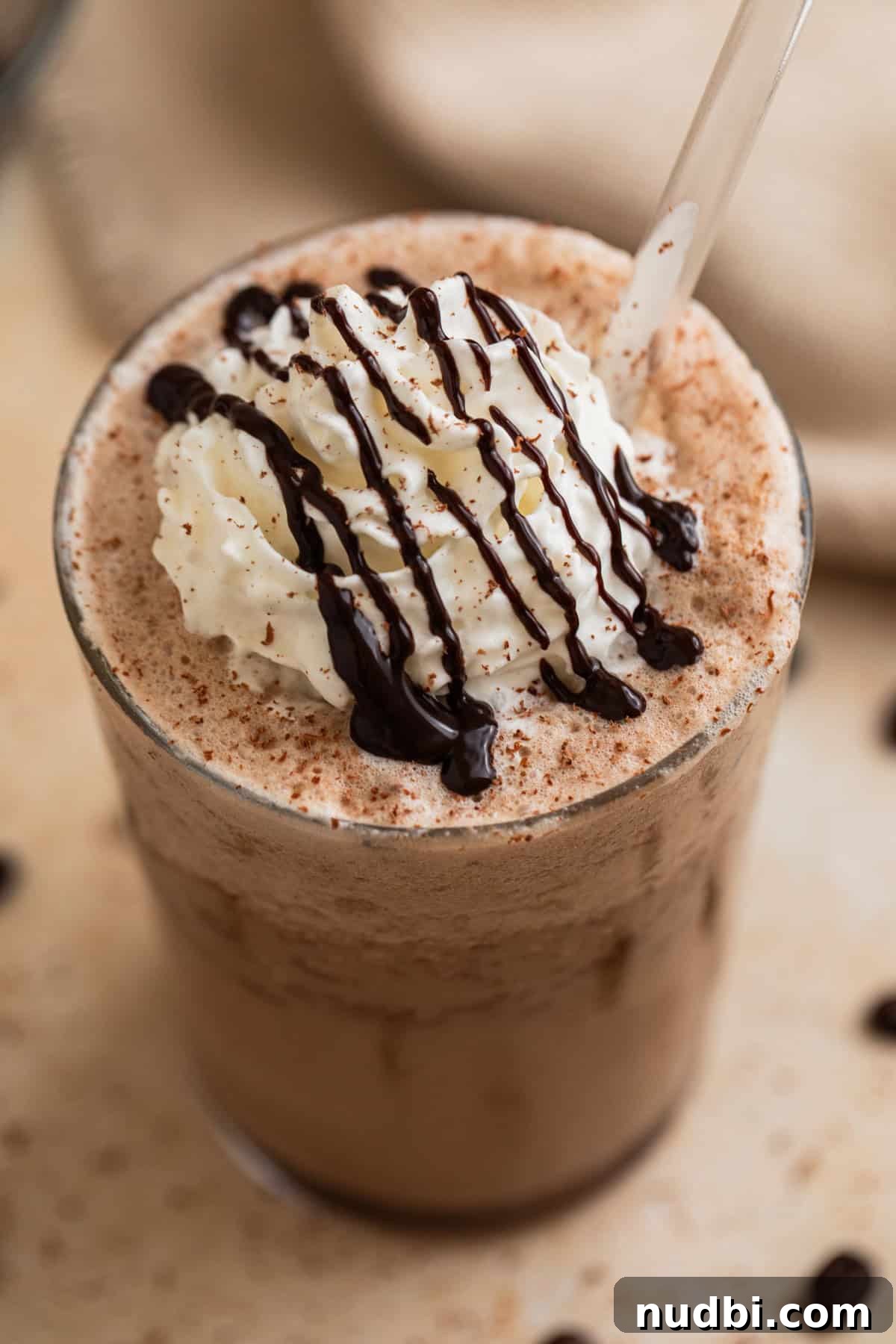 Homemade Mocha Frappuccino Recipe for Café-Style Iced Coffee 2 Mocha frappuccino in glass with whipped cream and chocolate drizzle on top.