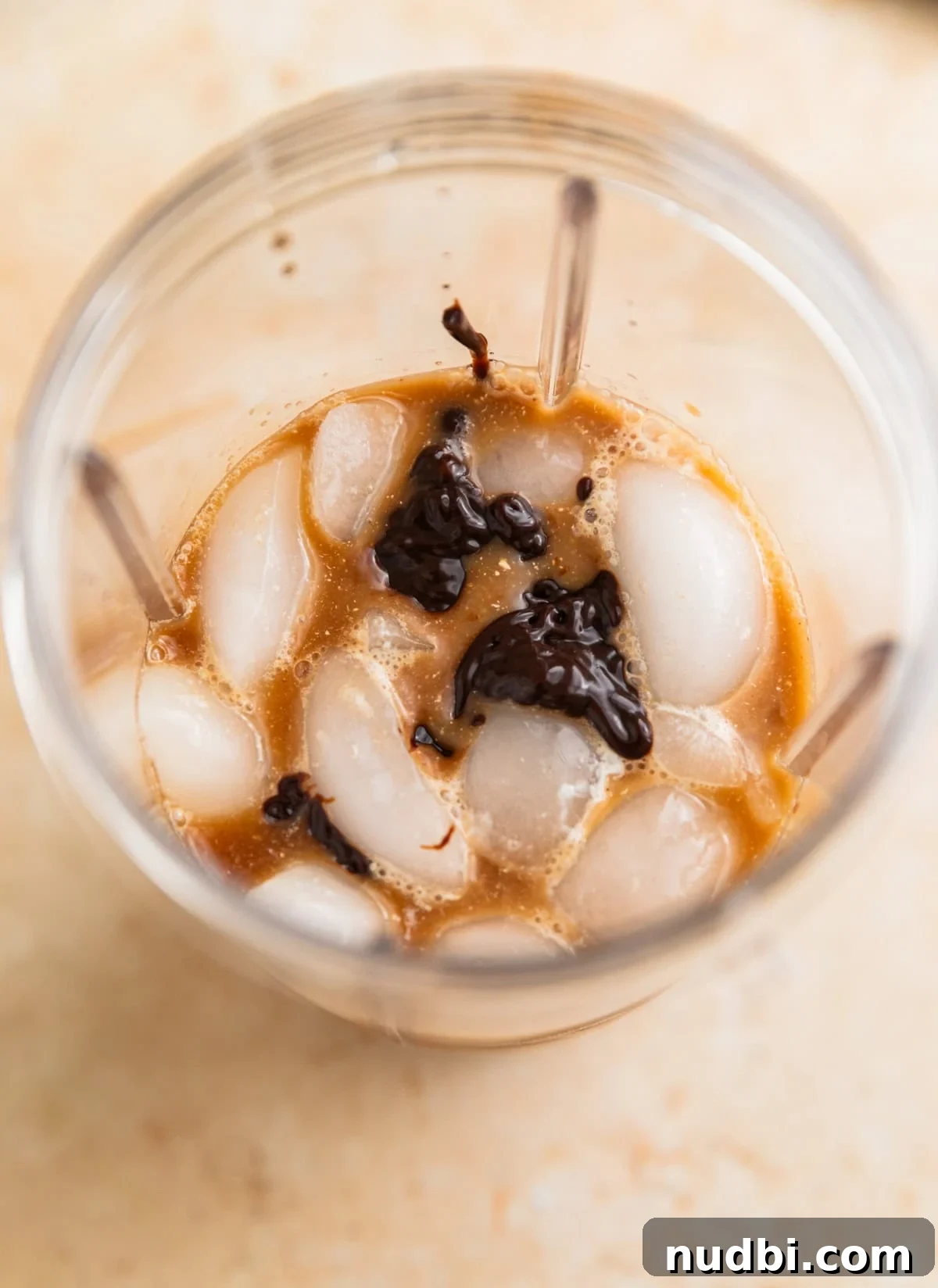 Homemade Mocha Frappuccino Recipe for Café-Style Iced Coffee 4 Ice, coffee, chocolate sauce and milk in blender before blending.