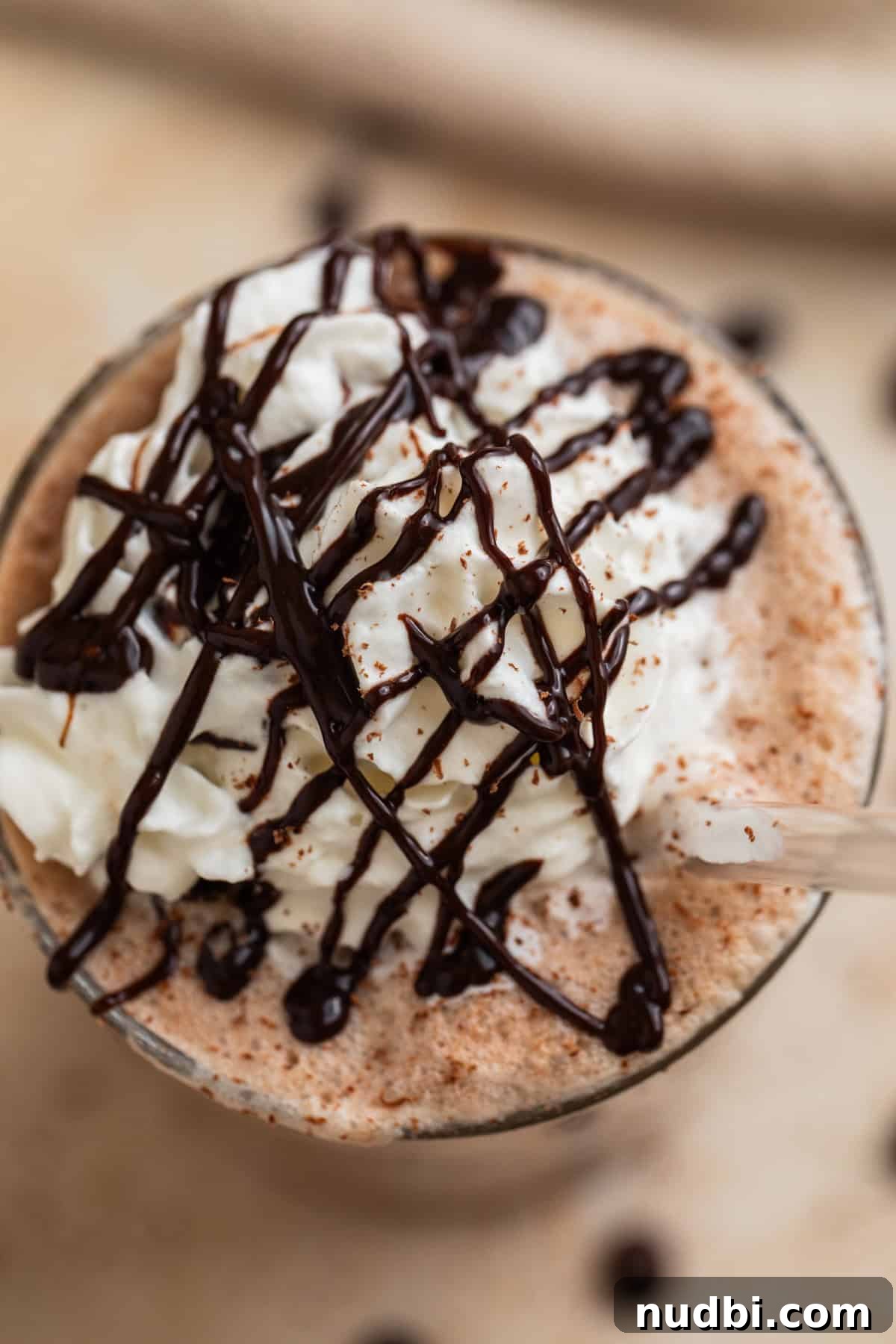 Homemade Mocha Frappuccino Recipe for Café-Style Iced Coffee 6 Homemade frappuccino in glass topped with chocolate drizzle.