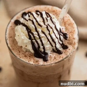 Homemade Mocha Frappuccino Recipe for Café-Style Iced Coffee 7 Mocha frappuccino iced coffee drink in glass with whipped cream and chocolate shavings.