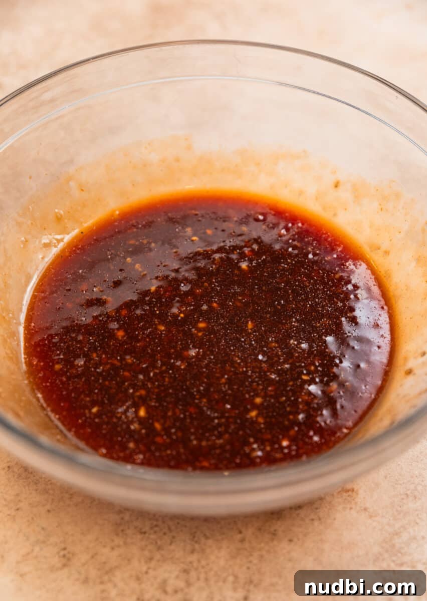 Honey Garlic Sheet-Pan Chicken Thighs Recipe 4 Honey garlic sauce whisked together in glass mixing bowl.