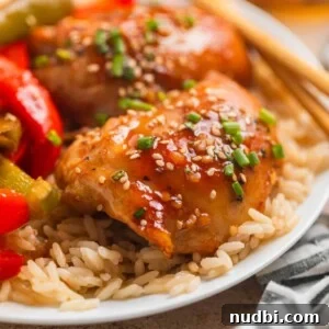 Honey Garlic Sheet-Pan Chicken Thighs Recipe 6 Honey garlic chicken thighs over rice with sliced bell peppers and chopsticks.