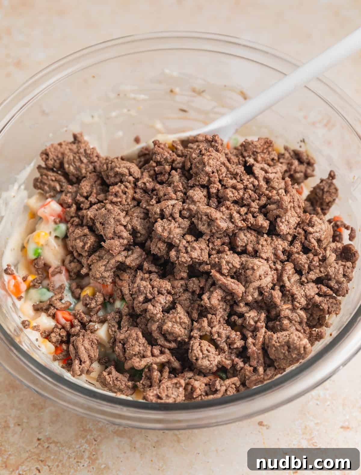 Savory Ground Beef Pot Pie Recipe with Flaky Crust 6 Ground beef added to bowl with other ingredients.