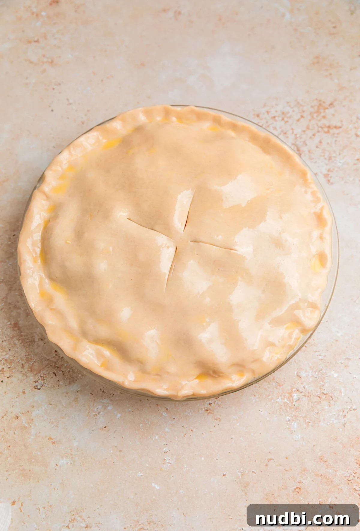 Savory Ground Beef Pot Pie Recipe with Flaky Crust 10 Egg wash on top of pie crust in dish with slits added.