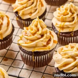 Salted Caramel Mocha Cupcakes Recipe for Coffee Lovers 5 Chocolate espresso cupcakes topped with caramel buttercream on cooling rack.