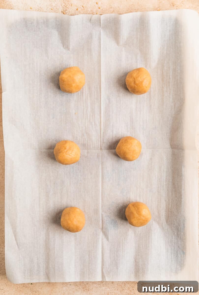 Chewy Snickerdoodle Cookies Filled with Caramel 11 Rolled caramel stuffed snickerdoodle cookie dough balls on baking sheet.
