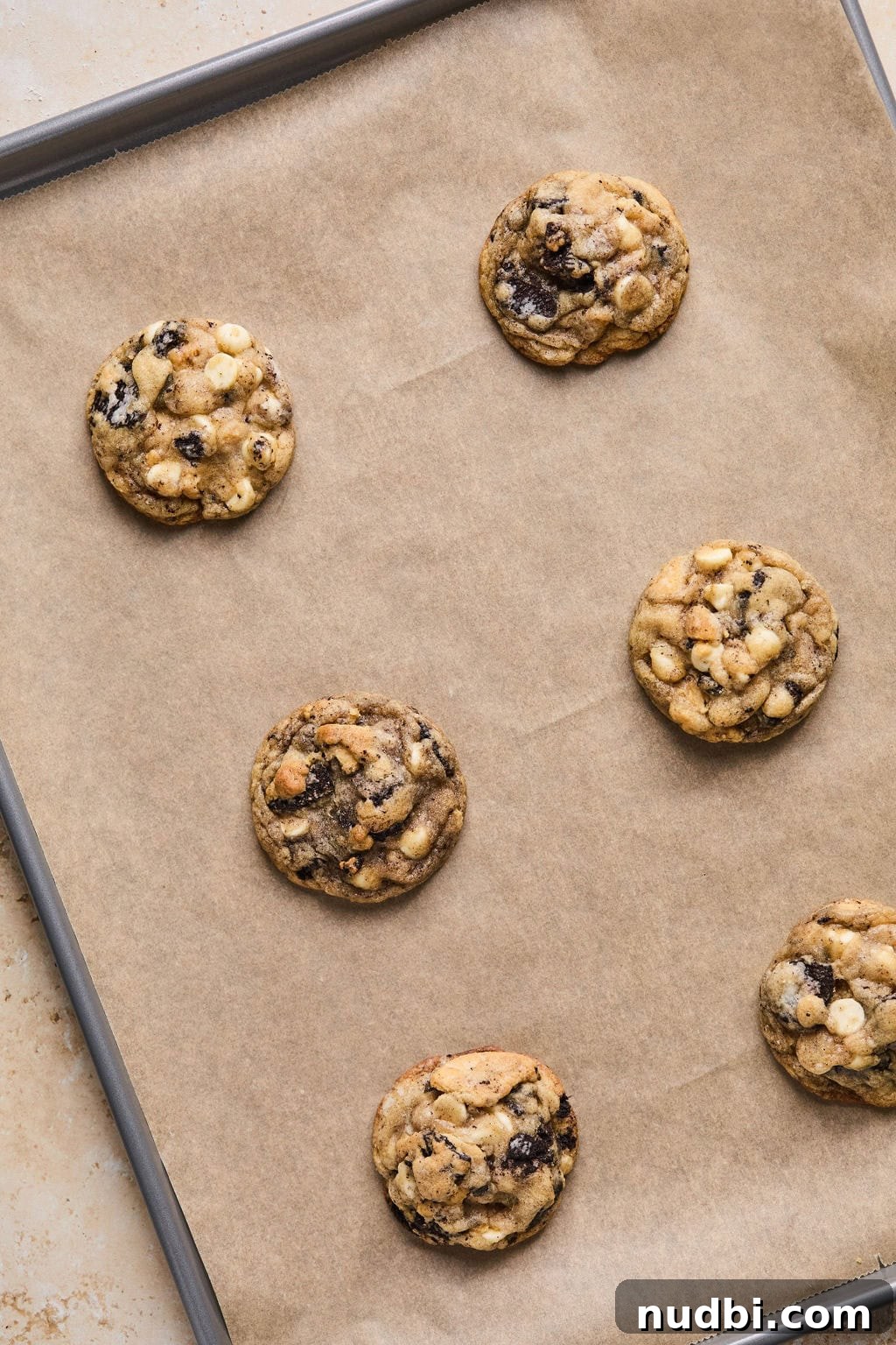 Oreo Chocolate Chip Cookies Recipe — Chewy Oreo-Stuffed Treats 15 Baked cookies and cream cookies on cookie sheet.
