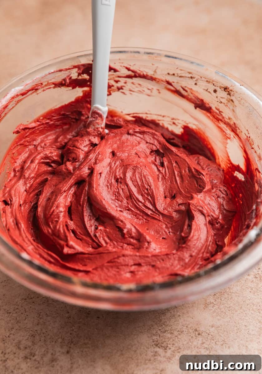 Red Velvet Cheesecake Dip Recipe — Creamy Party Dessert Dip 9 Red velvet dip in mixing bowl with white spoon.