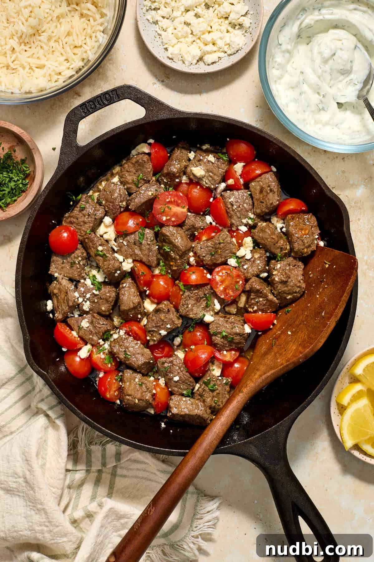 Mediterranean Steak Bites with Creamy Yogurt Herb Sauce 2 Cast iron skillet with steak bites, feta cheese and grape tomatoes.