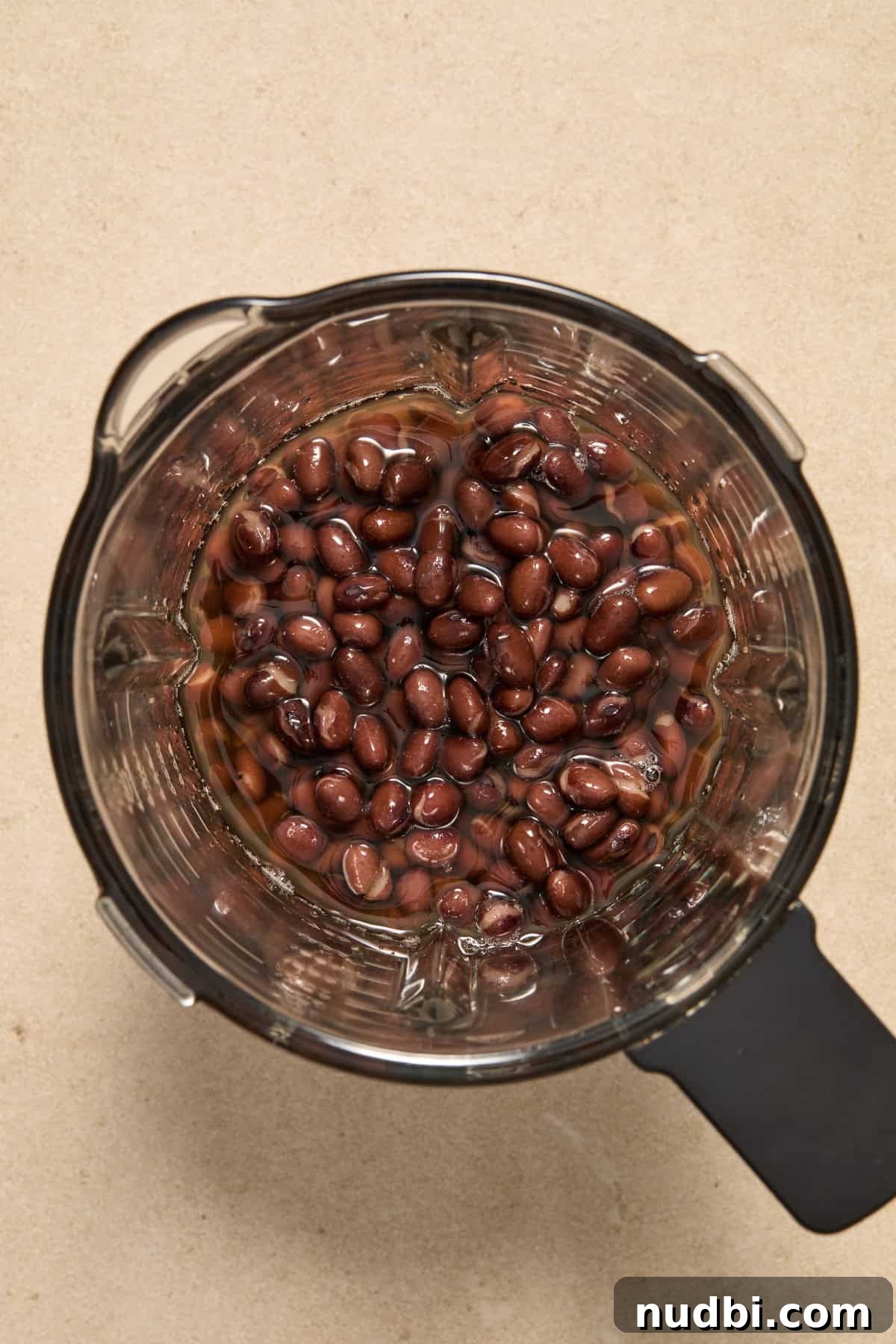 20-Minute Hearty Black Bean Soup Recipe for Weeknight Dinners 4 Black beans in food processor with vegetable broth before being blended.