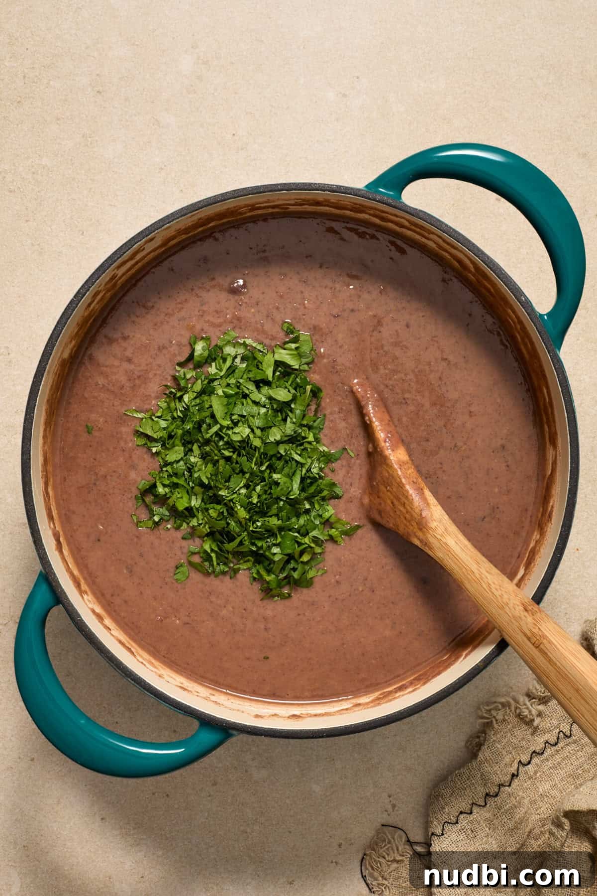 20-Minute Hearty Black Bean Soup Recipe for Weeknight Dinners 8 Black bean and salsa soup in pot with chopped cilantro added over top.