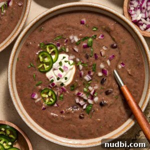 20-Minute Hearty Black Bean Soup Recipe for Weeknight Dinners 10 Black bean soup in bowl with spoon and toppings.