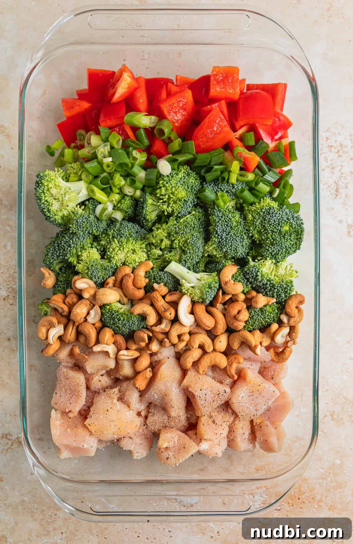 Crispy Baked Cashew Chicken with Garlic Soy Glaze 6 Red bell pepper, broccoli, green onion, cashews and chicken in baking pan.