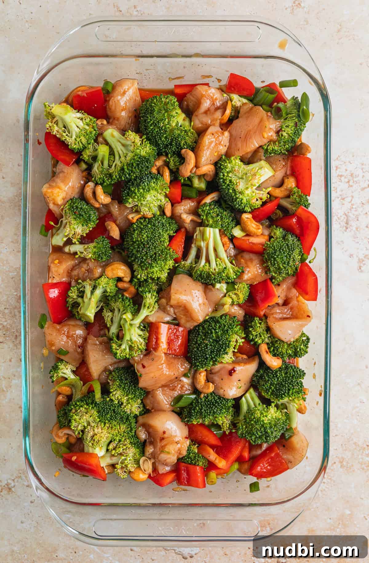 Crispy Baked Cashew Chicken with Garlic Soy Glaze 7 Cashew chicken ingredients in glass pan tossed together in sauce before baking.