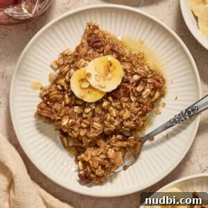Banana Bread Baked Oatmeal Recipe for Breakfast and Meal Prep 5 Banana bread baked oatmeal on plate with sliced bananas on top.