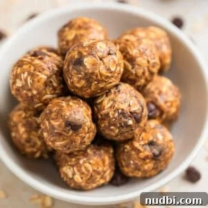 No-Bake Peanut Butter Oatmeal Energy Balls for Quick Snacks 9 White ceramic bowl with peanut butter oatmeal energy bites with chocolate chips and oats scattered around the bowl.