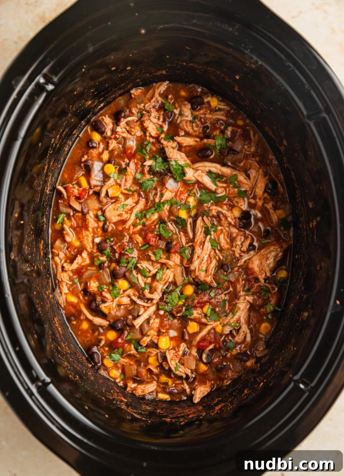 Slow Cooker Chicken Burrito Bowl: Flavorful Make-Ahead Recipe 8 Chicken burrito mixture in crockpot topped with chopped cilantro.