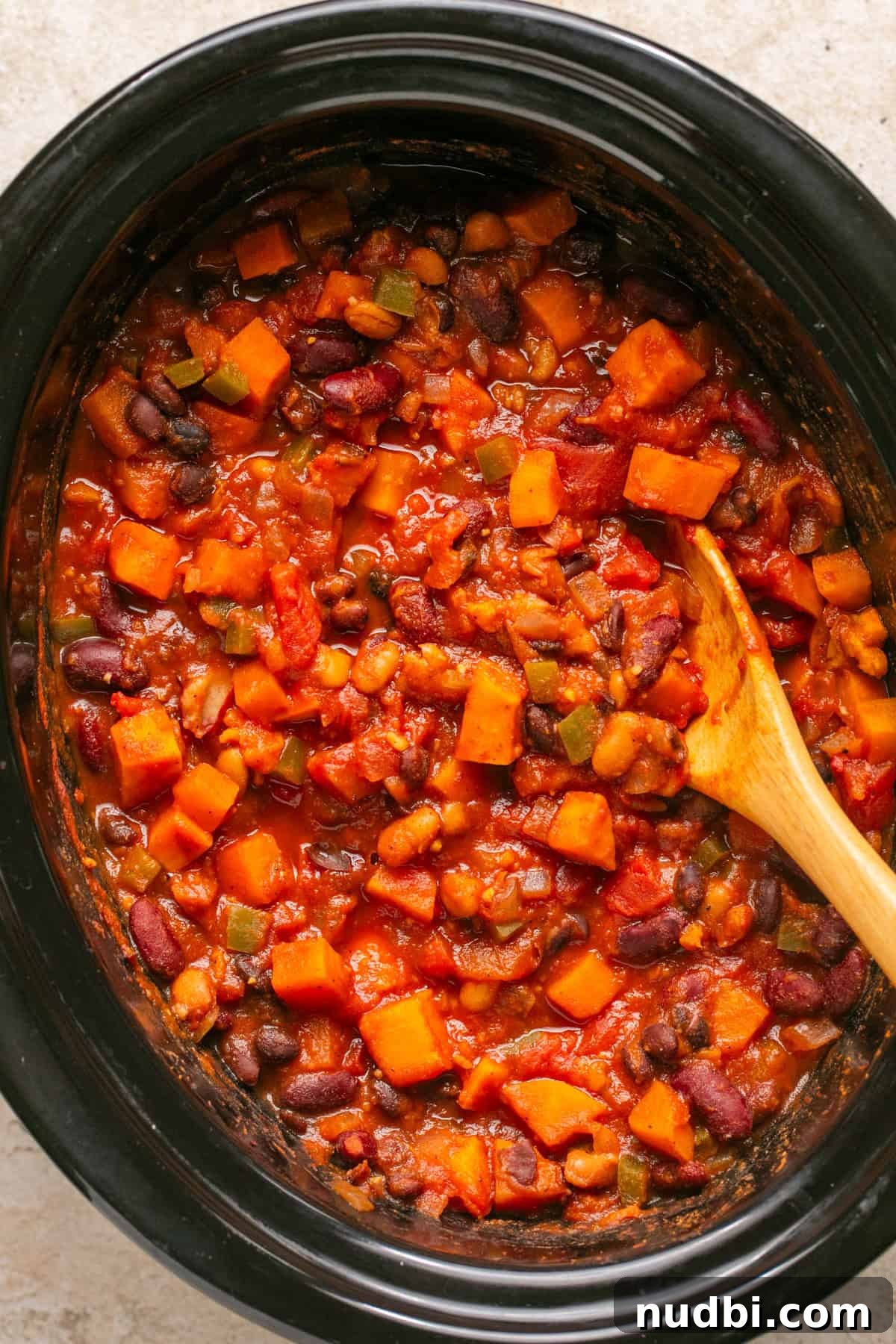 Slow Cooker Sweet Potato and Black Bean Chili Recipe 7 Cooked crock pot sweet potato chili with wooden spoon.