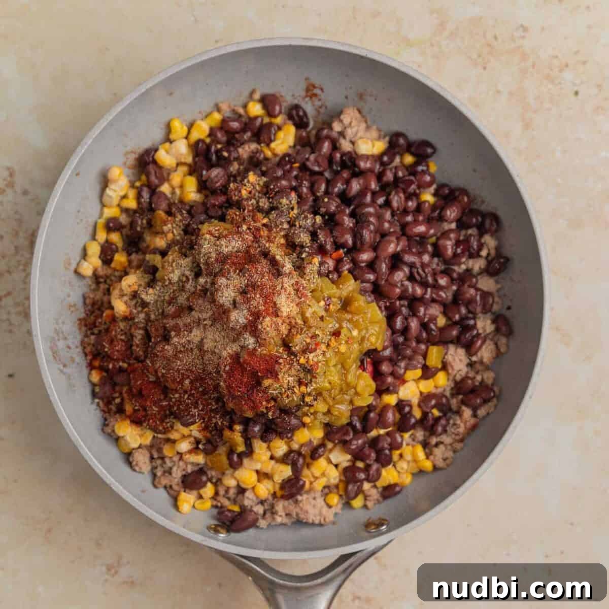 Taco-Stuffed Sweet Potatoes That Are Ready in 30 Minutes 6 Meat in skillet with diced tomatoes, beans, corn and other ingredients added.