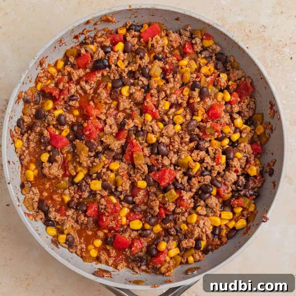Taco-Stuffed Sweet Potatoes That Are Ready in 30 Minutes 7 Ground turkey taco filling in skillet with corn and beans.