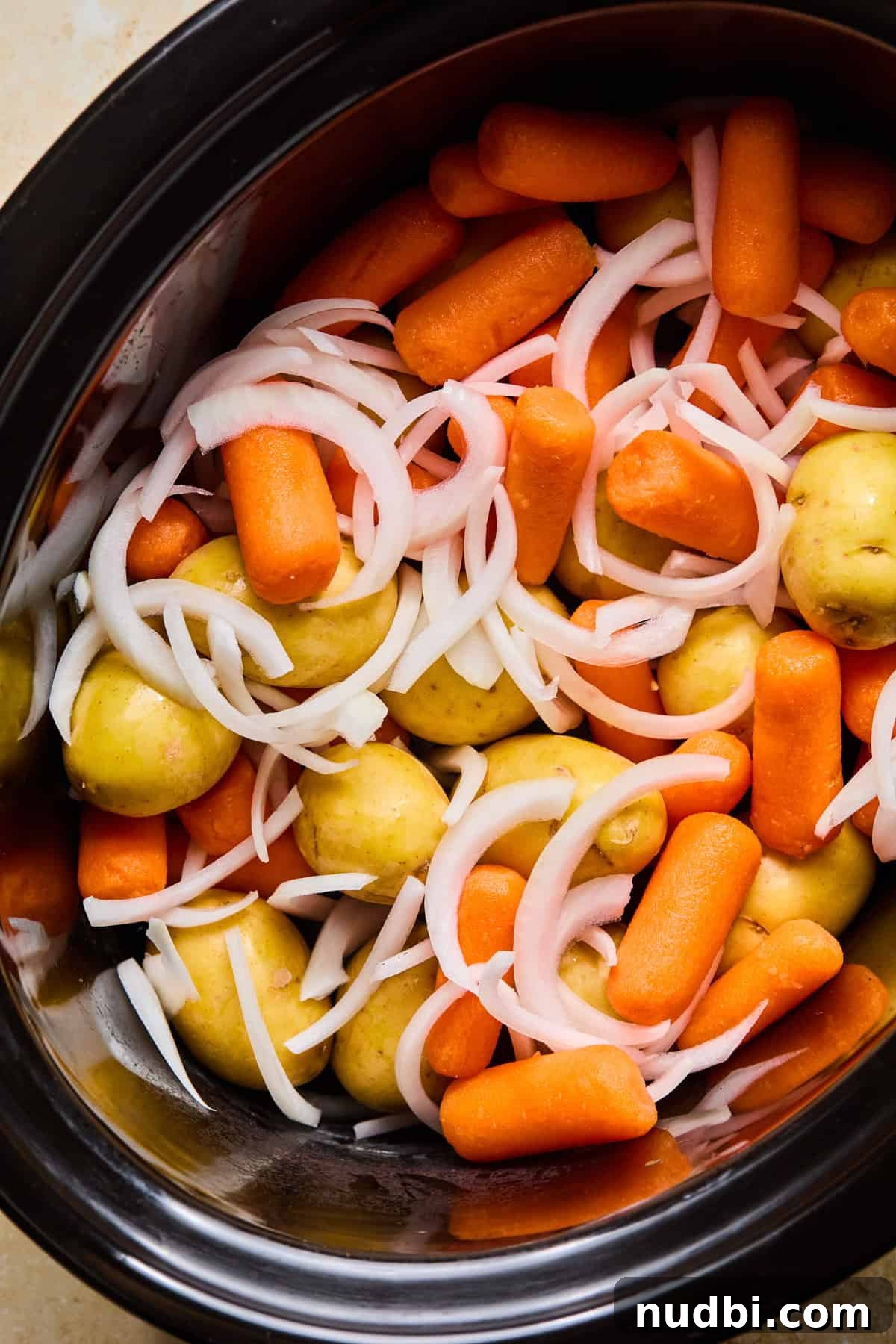 Slow-Cooked Chuck Roast Recipe for Tender, Juicy Beef 5 Carrots, onions and potatoes in crock pot.
