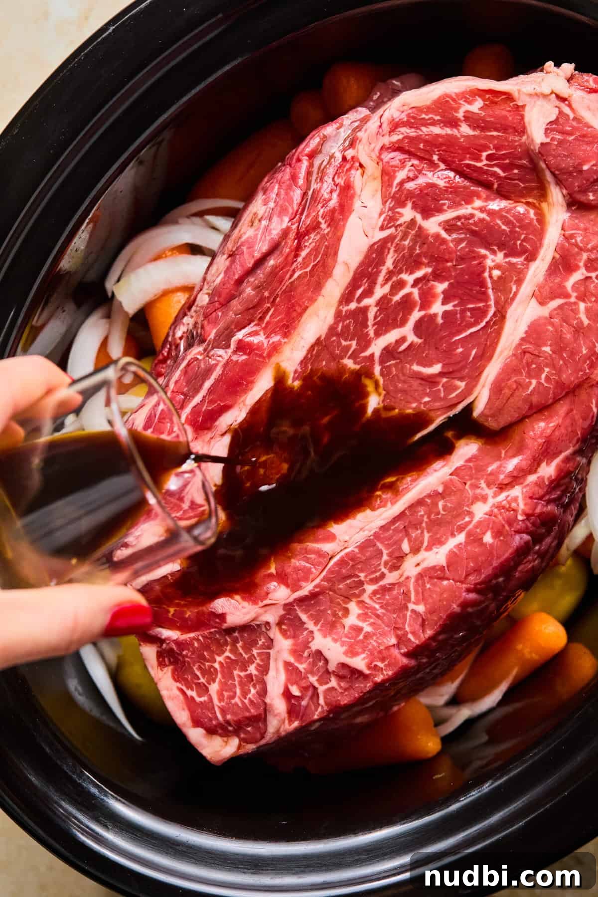 Slow-Cooked Chuck Roast Recipe for Tender, Juicy Beef 6 Chuck roast on top of vegetables in crock pot before cooking.