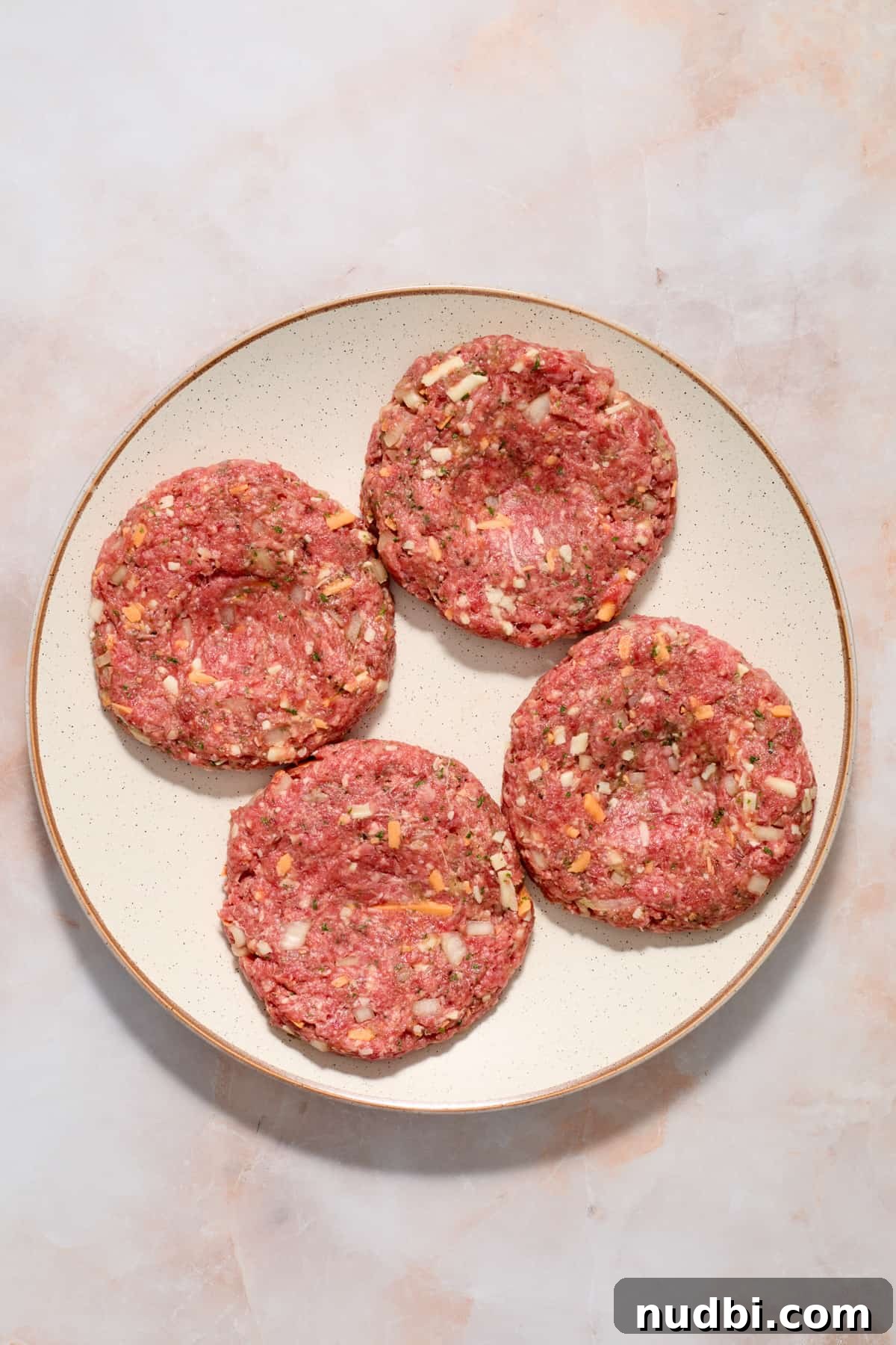 Crispy Air Fryer Hamburgers: Juicy Patties in Minutes 6 Hamburger patties on plate prepped with dimple in center.