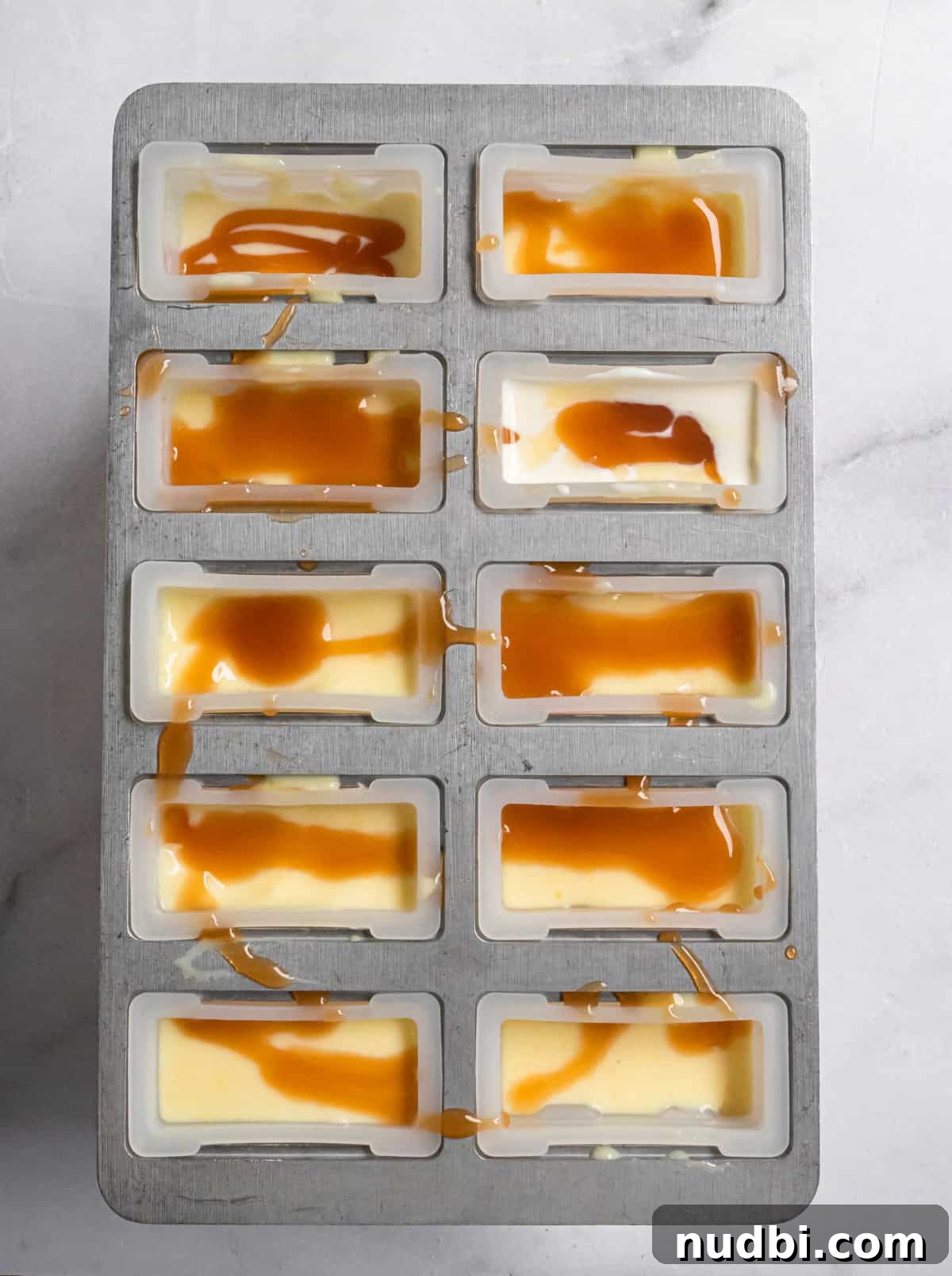 Homemade Jello Pudding Pops: Creamy Frozen Treat Recipe 4 Popsicle molds filled with mixture and caramel.