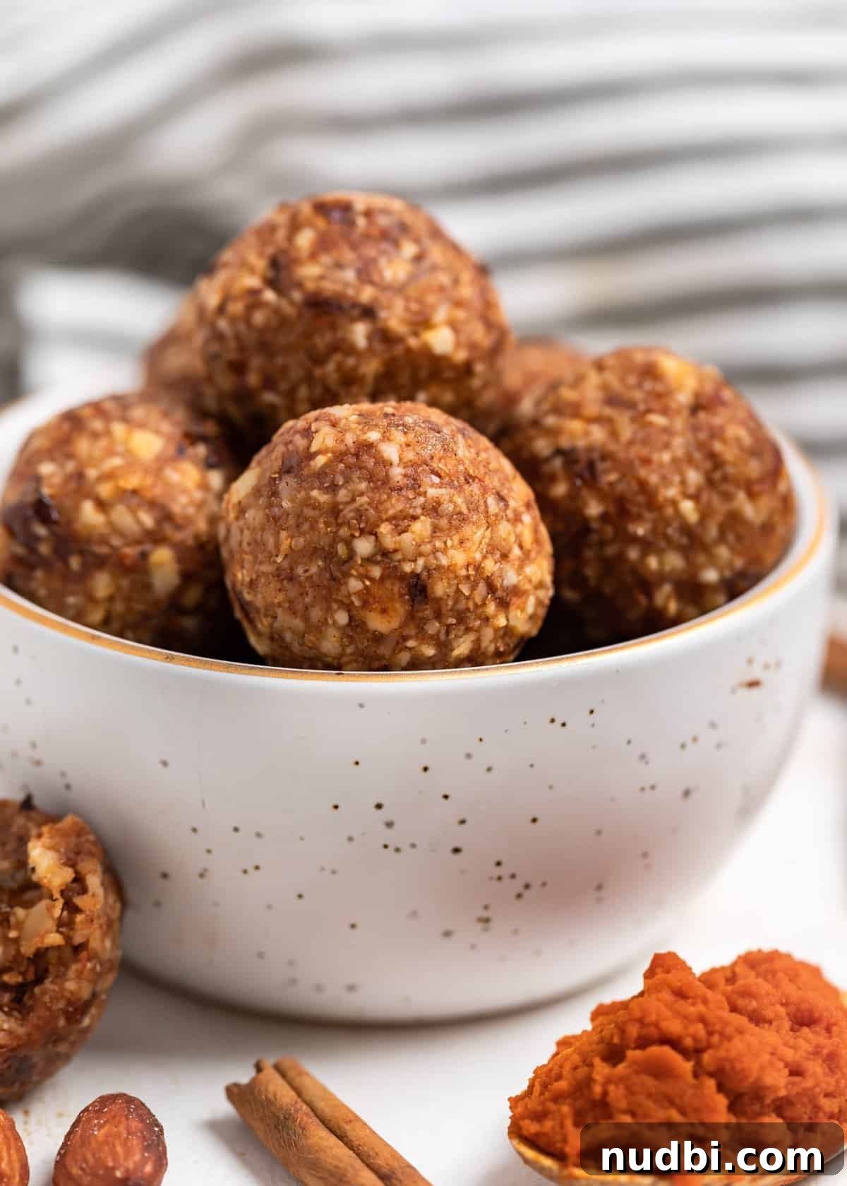 Pumpkin Pie Energy Bites: Fall Snack Recipe with Oats & Dates 4 Pumpkin energy bites in bowl.