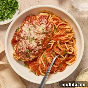 Spinach and Ricotta Stuffed Chicken Breast Recipe 11 Spinach ricotta chicken breast topped with freshly chopped parsley and parmesan in bowl with pasta.