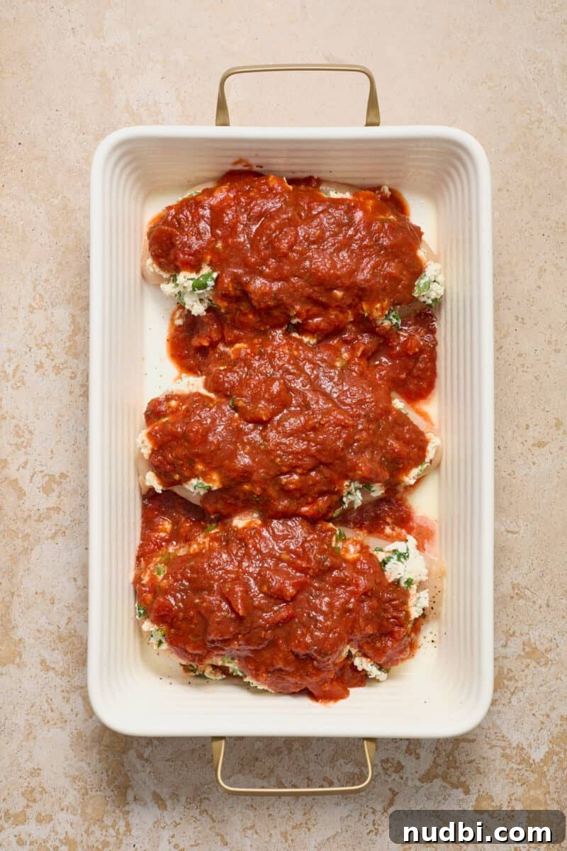 Spinach and Ricotta Stuffed Chicken Breast Recipe 7 Chicken breasts in pan covered with ricotta mixture and marinara.
